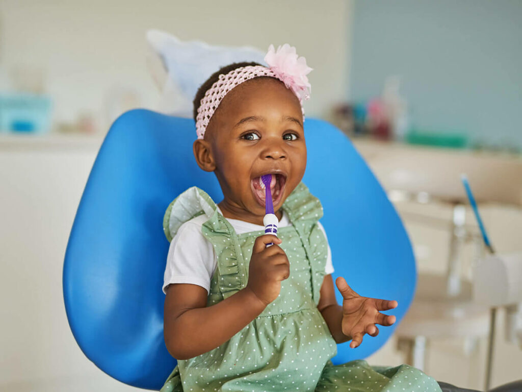 smiling toddler with a toothbrush