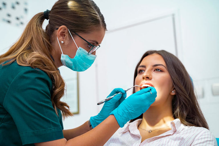A dental hygienist performs a regular dental checkup on a patient